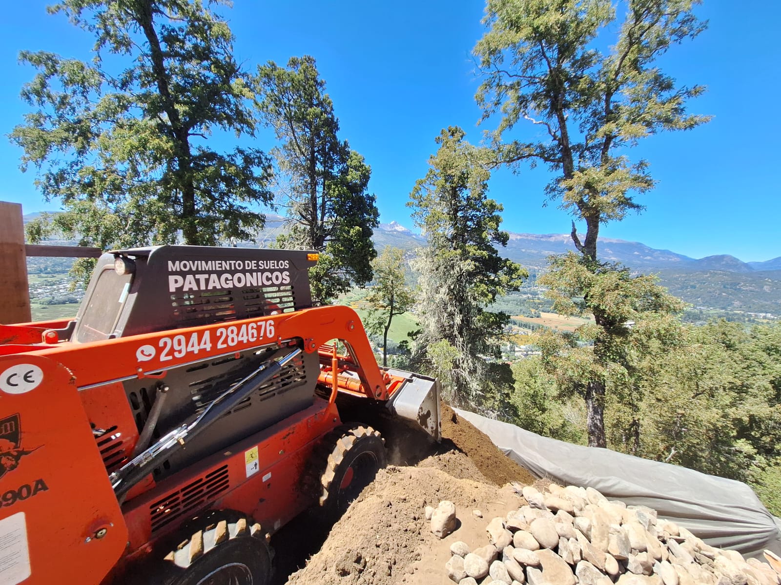 Minicargadora de Movimiento de Suelos Patagónicos trabajando con vista a las montañas de San Martín de los Andes
