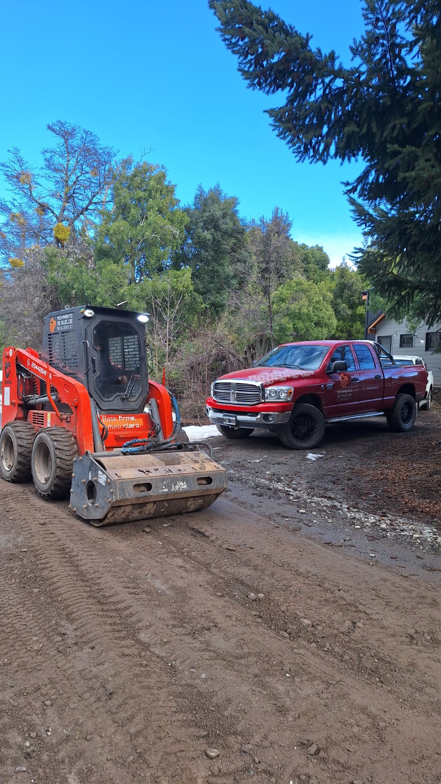 Minicargadora con vibrocompactador y camioneta de Movimiento de Suelos Patagónicos en obra
